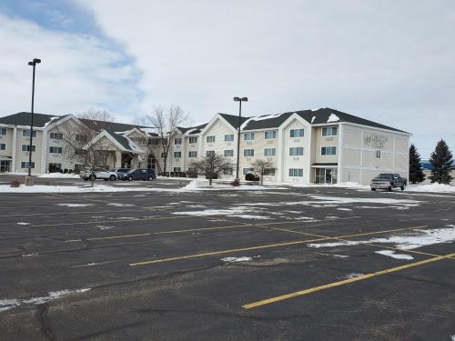 an empty parking lot with a large apartment complex at Cobblestone Suites - Oshkosh in Oshkosh