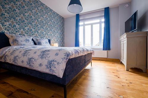 a bedroom with a bed with blue floral wallpaper at Villa Louise Oostende in Ostend