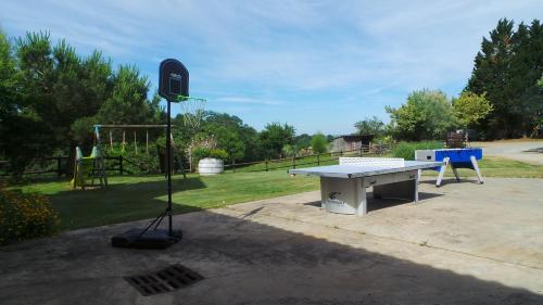 a ping pong table and a basketball hoop in a yard at Retour Au Source in Monprimblanc