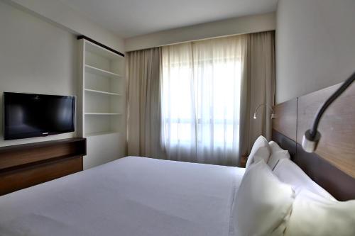 a hotel room with a bed and a television at Quality Hotel & Suítes São Salvador in Salvador