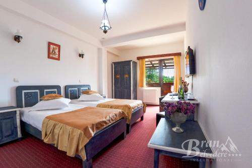a hotel room with two beds and a table at Bran Belvedere International in Bran