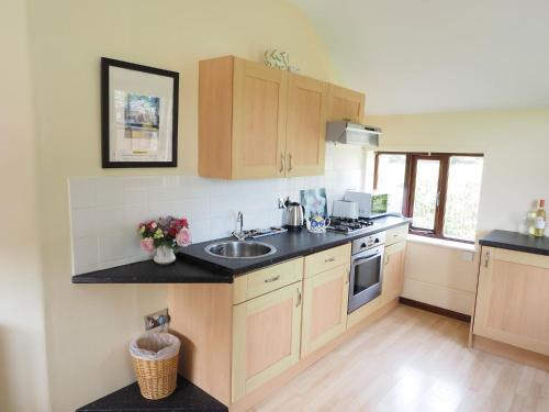 a kitchen with a sink and a counter top at Swallow Cottage at Duffryn Mawr Cottages in Hensol
