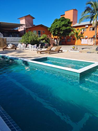 a swimming pool with blue water in a resort at Pousada Village Garopaba in Garopaba