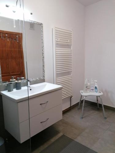 a bathroom with a sink and a mirror and a table at Pensiunea Casa Butnarului in Geoagiu de Sus