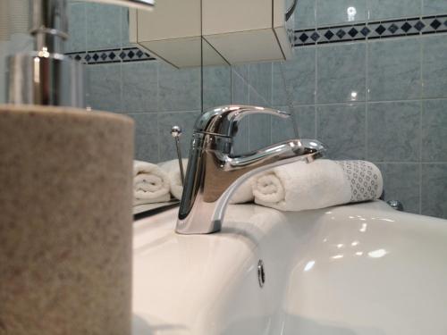 a bathroom sink with a faucet and towels on it at Central Studio Budapest in Budapest