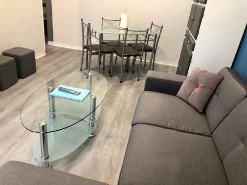 un salon avec un canapé et une table en verre dans l'établissement LE DRAKKAR - 1 chambre - 4 personnes - Proximité de la plage, à Saint Martin de Brehal