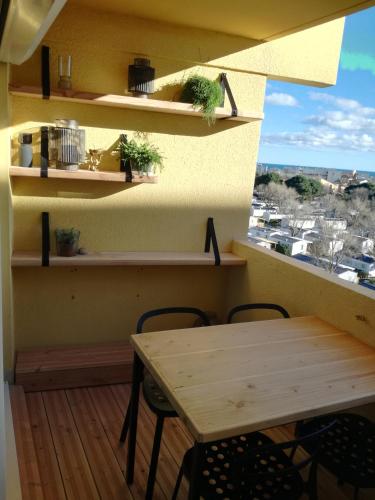 une table et des chaises dans une pièce avec une fenêtre dans l'établissement Bel appt T2 4p confortable avec vue mer imprenable, à Narbonne-Plage