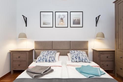 a bedroom with a bed and three pictures on the wall at Apartament Nadmorski Dwór in Gdańsk