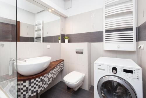 een badkamer met een wasmachine, een wasmachine en een droger bij Apartament Nadmorski Dwór in Gdańsk