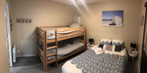 um quarto com 2 beliches e uma cama em LE DRAKKAR - 1 chambre - 4 personnes - Proximité de la plage em Saint Martin de Brehal