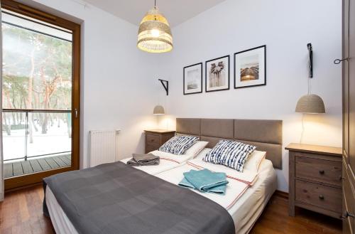 a bedroom with a large bed and a window at Apartament Nadmorski Dwór in Gdańsk