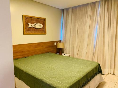 - une chambre avec un lit et une photo d'un poisson sur le mur dans l'établissement Marulhos Resort, à Porto de Galinhas