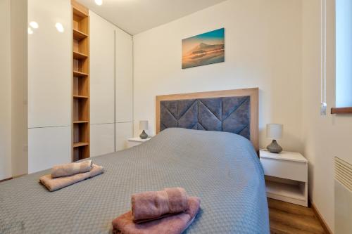 ein Schlafzimmer mit einem großen Bett mit zwei Handtüchern darauf in der Unterkunft Apartman Neva Zlatibor in Zlatibor