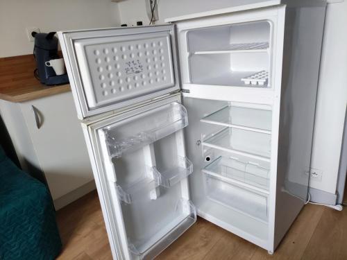 un réfrigérateur vide avec sa porte ouverte dans une cuisine dans l'établissement Joli petit T2 entre port et vieille ville, à Boulogne-sur-Mer