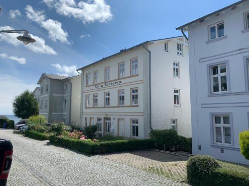 un gran edificio blanco sentado junto a una calle en Villa Victoria mit Meerblick, en Sassnitz