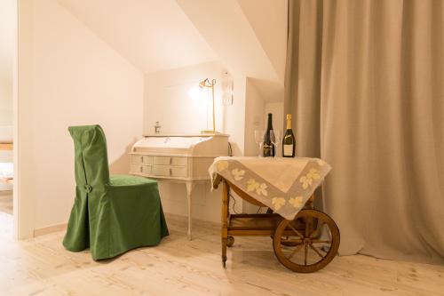 a room with a table and a chair with wine bottles at B&B COL DE LE MOLE - DOLOMITI BELLUNESI in Belluno