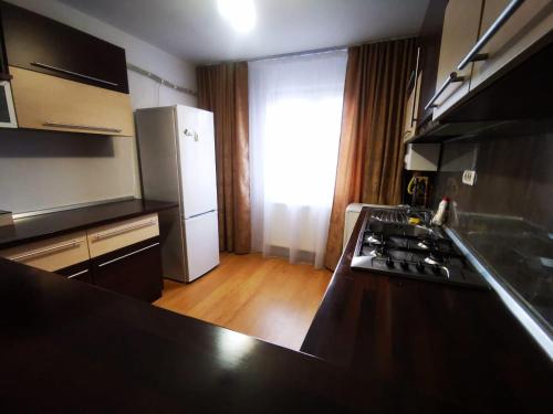 uma cozinha com um balcão preto e um frigorífico em L&A apartments - Circumvalatiunii em Timisoara