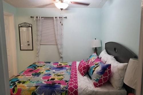 um quarto com uma cama com um edredão colorido em The Cozy Corner em Nassau