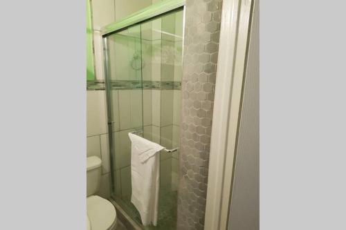 uma casa de banho com uma cabina de duche em vidro e um WC. em The Cozy Corner em Nassau