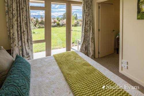 a bedroom with a bed and a large window at Night Sky Cottages - Kea Cottage - LUXURY in Twizel