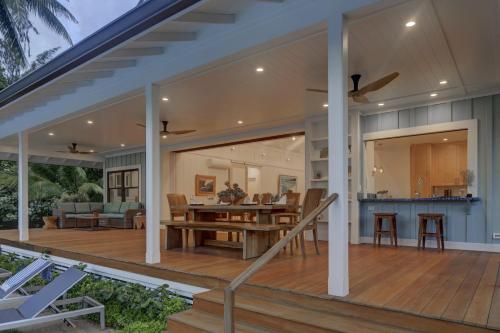 an open deck with a dining and living room on it at Gorgeous Renovated 1937 Plantation Style Beach House 50 Steps to the Center of the Beach home in Kailua