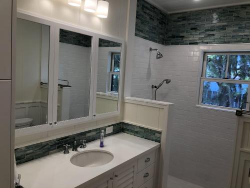a bathroom with a sink and a mirror at Gorgeous Renovated 1937 Plantation Style Beach House 50 Steps to the Center of the Beach home in Kailua