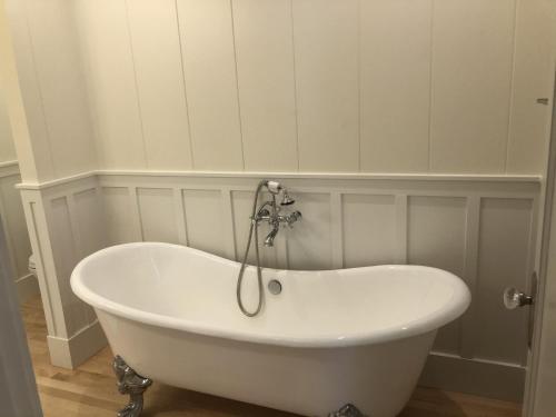 a white bath tub sitting in a bathroom at Gorgeous Renovated 1937 Plantation Style Beach House 50 Steps to the Center of the Beach home in Kailua