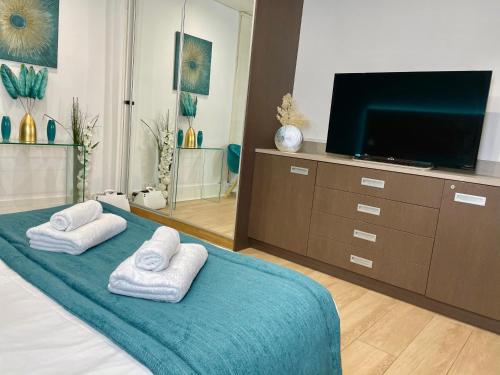 - une chambre avec une télévision et 2 serviettes sur un lit dans l'établissement Appart' Weekly Quartier Impérial Gare, à Metz