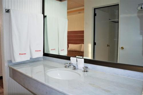 ein Badezimmer mit einem Waschbecken und einem großen Spiegel in der Unterkunft Hotel Princesa in Mexiko-Stadt