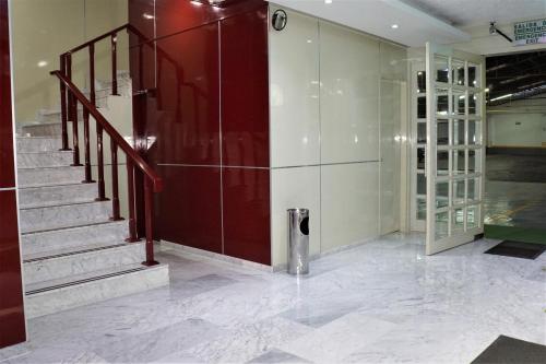 a lobby with a staircase and a red wall at Hotel Princesa in Mexico City