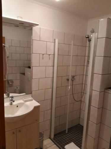 uma casa de banho com um chuveiro e um lavatório. em Kurpark-Residenz Deidesheim em Deidesheim