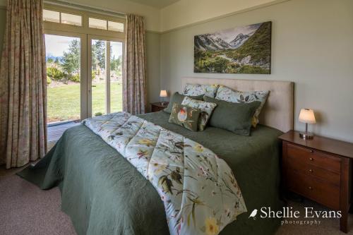 a bedroom with a large bed and a window at Night Sky Cottage - Kahu Cottage - HOT TUB in Twizel
