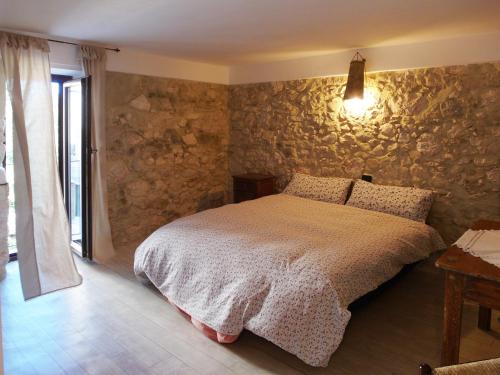 een slaapkamer met een bed en een stenen muur bij Stonehouse apartments 