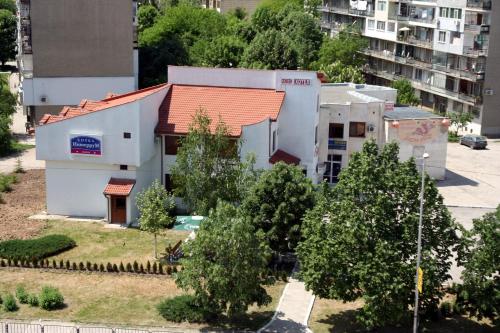 a small white building with a red roof at Interrum Hotel in Razgrad