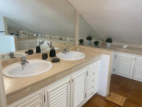 a bathroom with two sinks and a large mirror at Blue Marlin 6 in Pasito Blanco