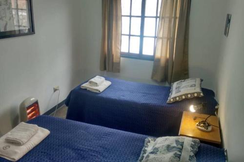 a bedroom with two beds and a table and a window at G Duplex estratégico en ciudad de Mendoza in Mendoza