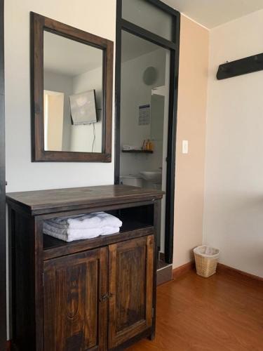 a bathroom with a wooden vanity with a mirror at Hotel Santa Elena Norte in Tunja
