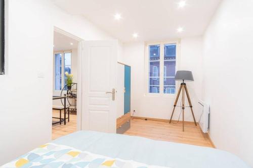 a white bedroom with a bed and a tripod at Appartement T2 Cosy Honfleur CityStay COEUR HONFLEUR Netflix Wifi in Honfleur