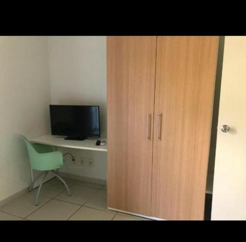 armadio in legno accanto a una scrivania con computer di Flat inteiro - Aldeia das águas a Barra do Piraí