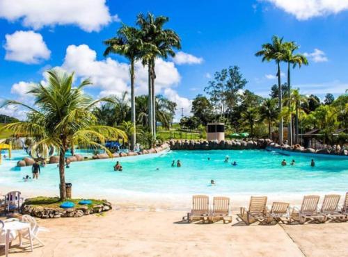 uma piscina num resort com pessoas a nadar nela em Flat inteiro - Aldeia das águas em Barra do Piraí