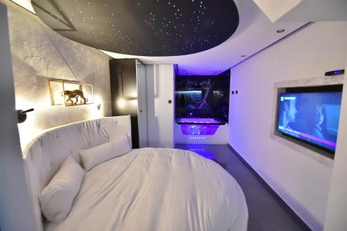 a bedroom with a white bed and a tv at סוויטת נסיכת המפרץ in Eilat