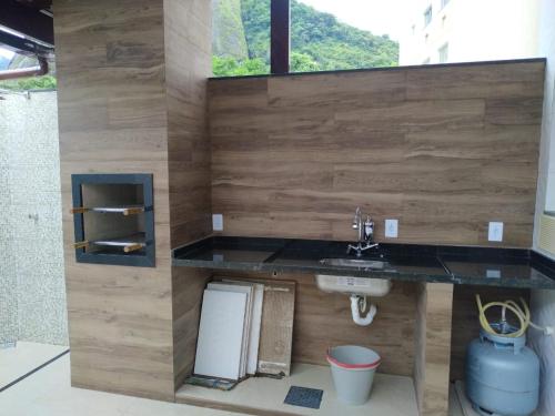 uma casa de banho com um lavatório e uma parede de madeira em Mangaratiba (casa mobiliada) em Mangaratiba