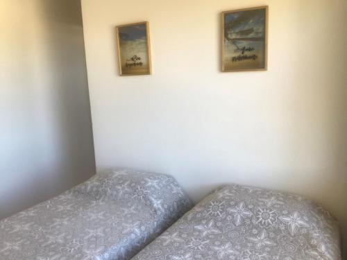 a bedroom with two beds and two pictures on the wall at Imbassai Summer Flats Village in Imbassai