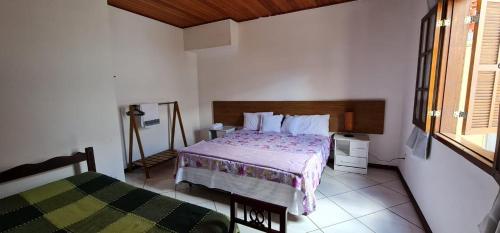 1 dormitorio con cama y ventana en Casa Ouro Preto, en Ouro Preto