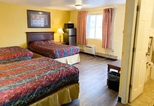Tempat tidur dalam kamar di Guest Ranch Motel