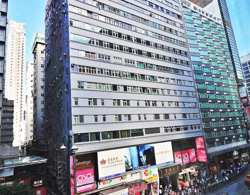 un edificio alto con anuncios al costado. en Crystal Hostel, en Hong Kong