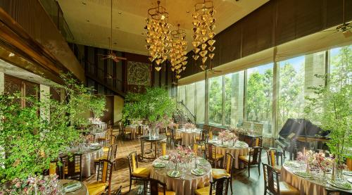 a dining room with tables and chairs and large windows at Kakegawa Grand Hotel in Kakegawa