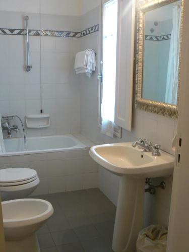 a bathroom with a toilet and a sink and a tub at Hotel Moderno in Siena