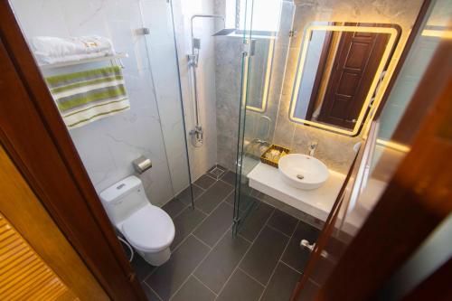 une petite salle de bain avec toilettes et lavabo dans l'établissement Sunset Hotel & Apartment, à Vung Tau