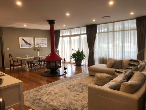 sala de estar con sofá y chimenea en Jewel of Brooklyn - Hawkesbury River Marina en Brooklyn